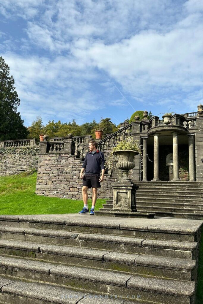Tom standing in front of Rydal Hall, with large pillars and steps